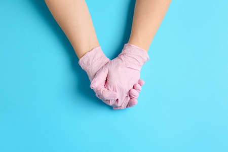Hands in protective gloves on color backgroundの写真素材