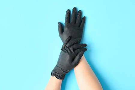 Hands in protective gloves on color backgroundの写真素材