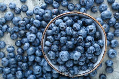 Bowl with tasty blueberry on gray backgroundの写真素材