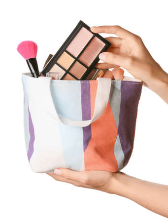 Female hands with cosmetic bag on white backgroundの写真素材
