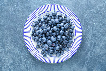 Plate with tasty blueberry on gray backgroundの写真素材