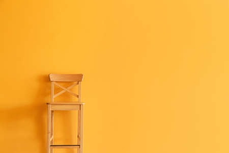 Wooden chair near color wallの写真素材