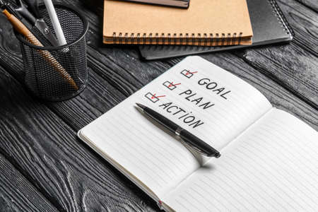 Text GOAL PLAN ACTION in notebook and pen on wooden backgroundの写真素材