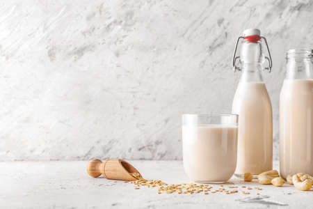 Bottles and glass of different milk on tableの写真素材