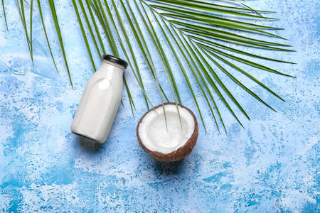 Bottle of coconut milk on color backgroundの写真素材