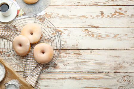 Tasty donuts and cup of coffee on wooden backgroundの写真素材