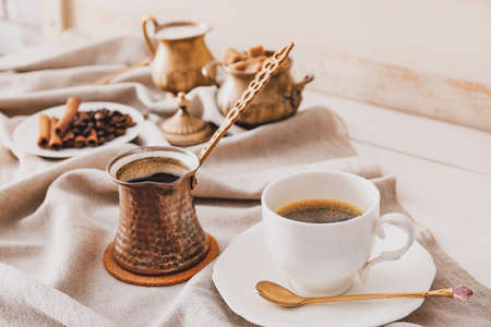 Cezve, cup of coffee, sugar and milk on tableの写真素材