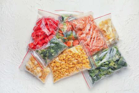 Plastic bags with frozen vegetables on light backgroundの写真素材
