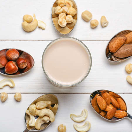 Glass of tasty vegan milk on wooden backgroundの写真素材