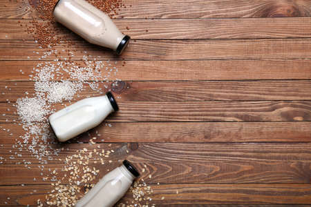 Bottles of different milk on wooden backgroundの写真素材
