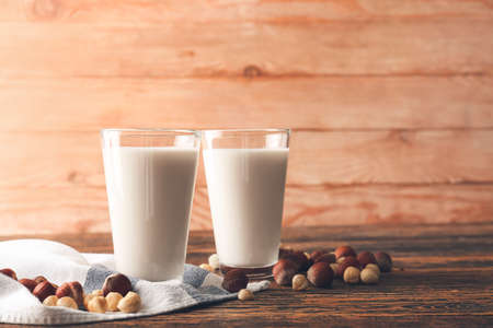 Glasses of tasty hazelnut milk on wooden backgroundの写真素材