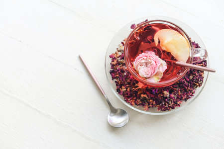 Cup with floral tea on light background