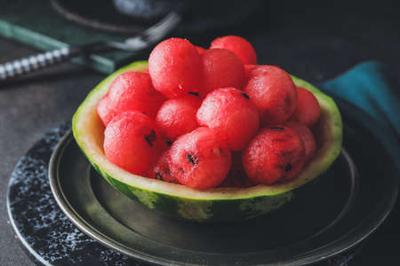 Tasty watermelon balls in ripe watermelon on dark backgroundの写真素材