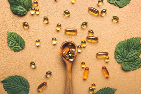 Composition with fish oil capsules on color background