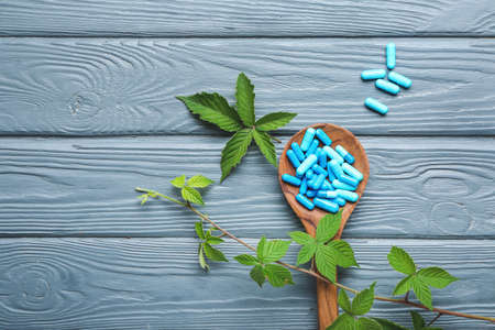 Spoon with plant based pills on wooden backgroundの写真素材
