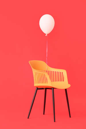 Modern chair with balloon on color backgroundの写真素材