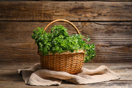 Fresh parsley in basket on wooden backgroundの写真素材
