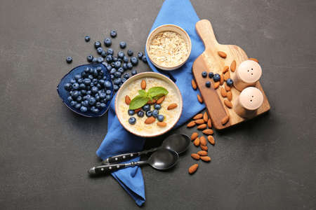 Bowl with tasty oatmeal and blueberry on table