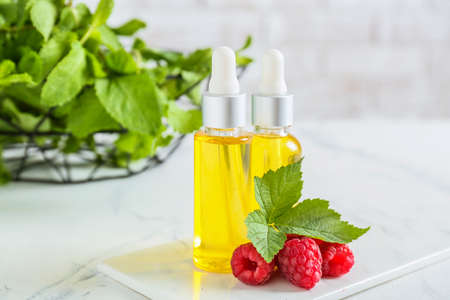 Bottles of raspberry essential oil on table