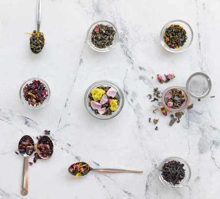 Composition with dry tea leaves and flowers on light backgroundの写真素材