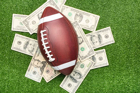 Money and rugby ball on color background. Concept of sports bet