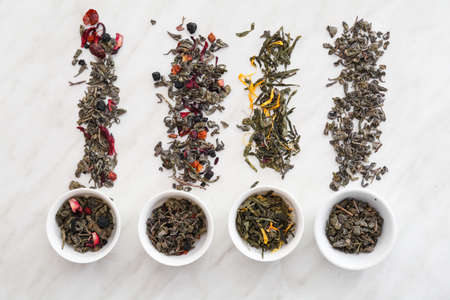 Bowls with different sorts of green tea on light background