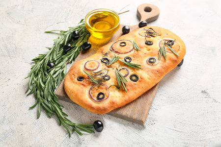 Board with traditional Italian focaccia on light backgroundの写真素材