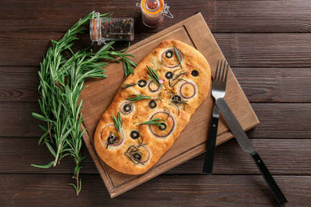 Board with traditional Italian focaccia on wooden backgroundの写真素材