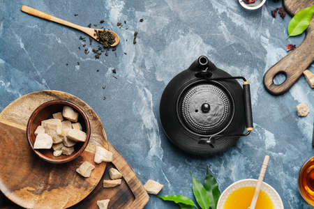 Composition with teapot, sugar and honey on color background