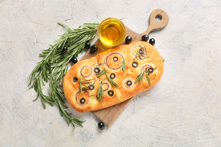 Board with traditional Italian focaccia on light backgroundの写真素材