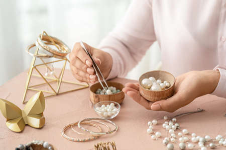 Female designer making jewelry at workplaceの写真素材