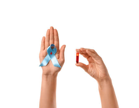 Female hands with awareness ribbon and blood sample on white background. Diabetes concept