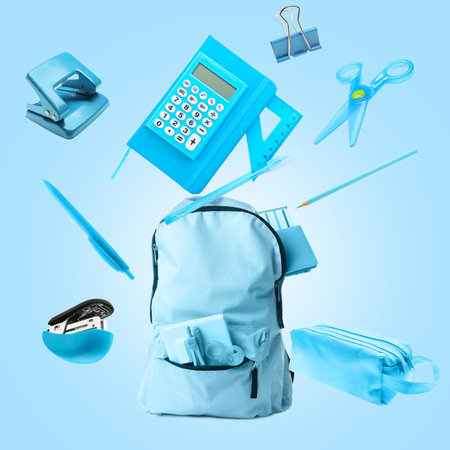 Backpack with flying school supplies on color backgroundの写真素材