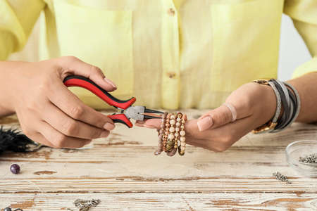 Female designer making jewelry at workplace