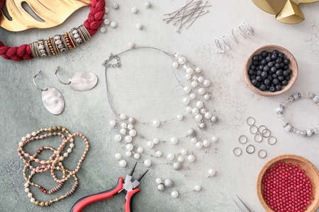 Workplace of jewelry designer with tools and beads on light backgroundの写真素材