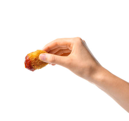 Female hand with tasty chicken nugget on white backgroundの写真素材