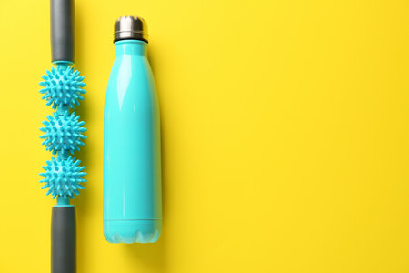 Body roller with bottle of water on color backgroundの写真素材