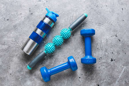 Body roller with dumbbells and bottle of water on grunge backgroundの写真素材