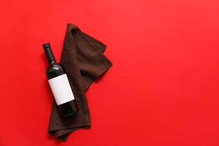 Bottle of wine with blank label and napkin on color backgroundの写真素材
