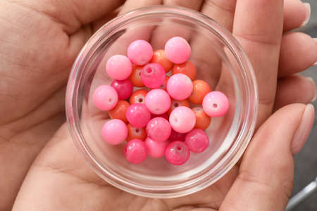 Female jewelry designer with beads, closeup