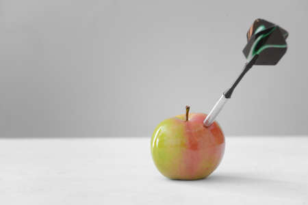 Dart with apple on light background