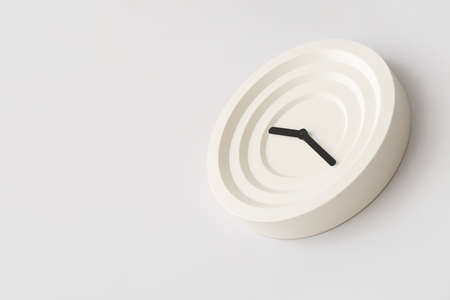 Modern clock hanging on light wall