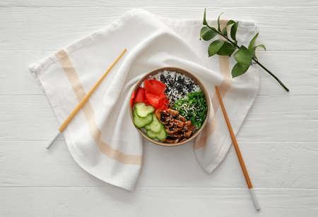 Bowl with tasty rice and vegetables on table