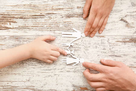 Hands of family with human figures on wooden backgroundの写真素材
