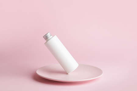 Bottle of cosmetic product and plate on color backgroundの写真素材