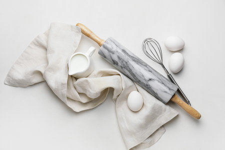 Ingredients for dough and rolling pin on white backgroundの写真素材