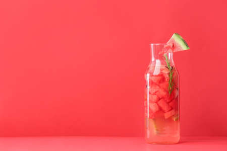 Bottle of cold watermelon lemonade on color backgroundの写真素材