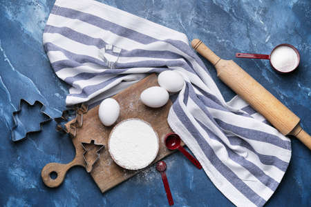 Ingredients for dough and rolling pin on color background