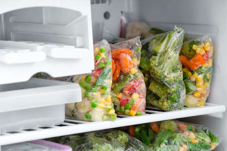 Plastic bags with frozen vegetables in refrigeratorの写真素材