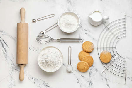 Ingredients for cookies and rolling pin on light background